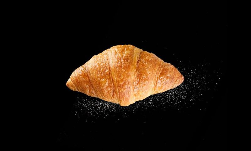 Buttercroissant der Bäckerei Mareis auf schwarzem Hintergrund.